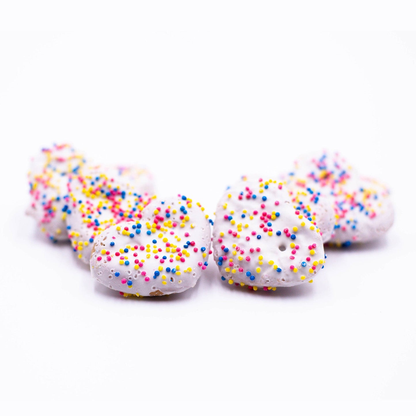 Small pile of yogurt coated confetti heart dog treats.